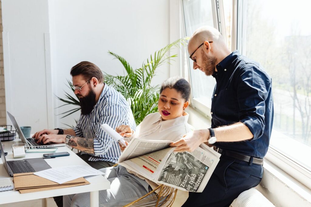 Mastering the First Impression: Your intriguing post title goes here Three colleagues collaborating in a bright office, reading and working on laptops.